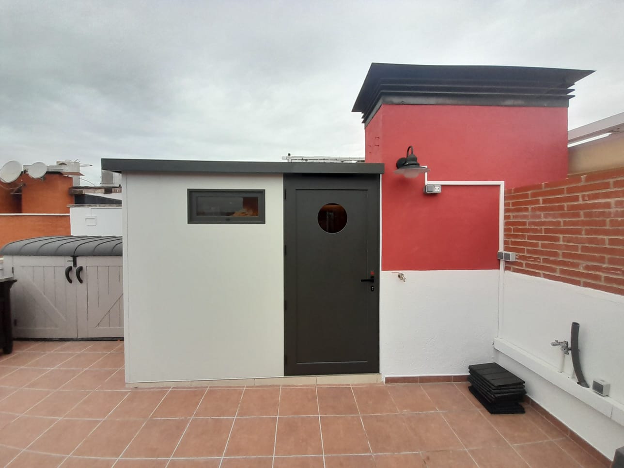 Caseta para terraza con baño, suelo de hormigón y porcelánico, estructura con panel sándwich de 5 cm y carpintería con vidrios bronce