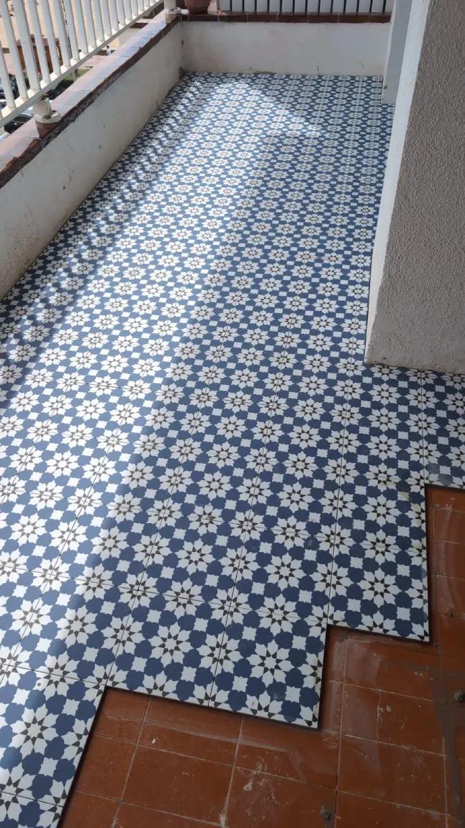 Suelo porcelánico imitación hidráulico instalado en terraza exterior en Lloret de Mar